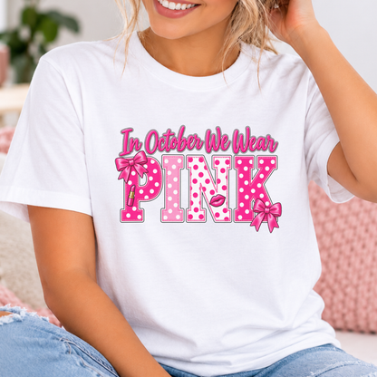 Woman wearing a white In October We Wear Pink polka dot breast cancer awareness shirt