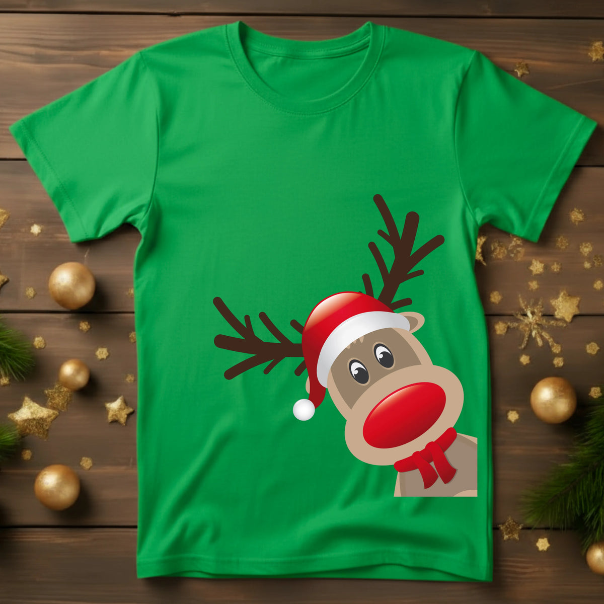 Green t-shirt with a cartoon reindeer design on a wooden surface with Christmas decorations.