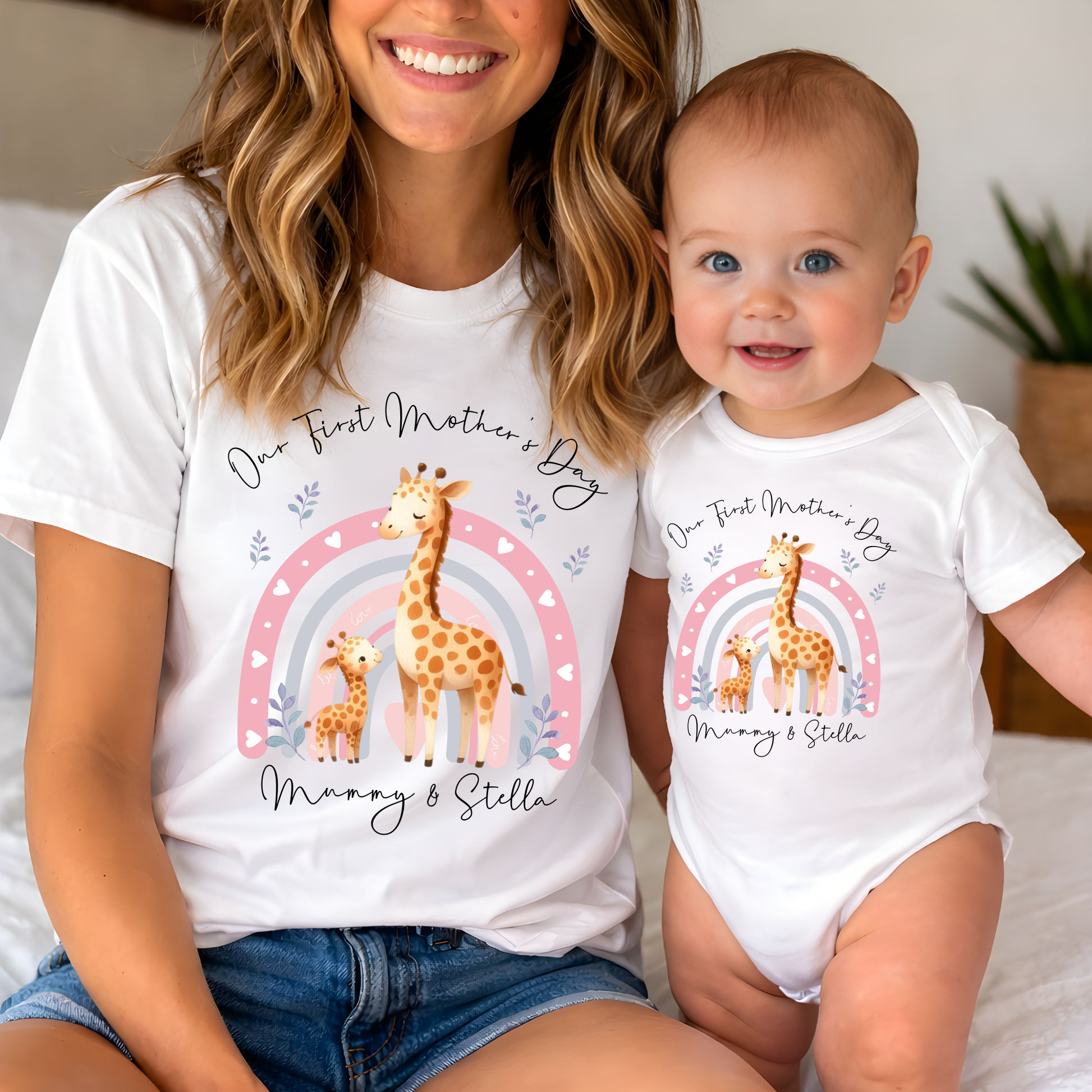 Woman and baby wearing matching 'First Mother's Day' outfits with giraffe illustrations.