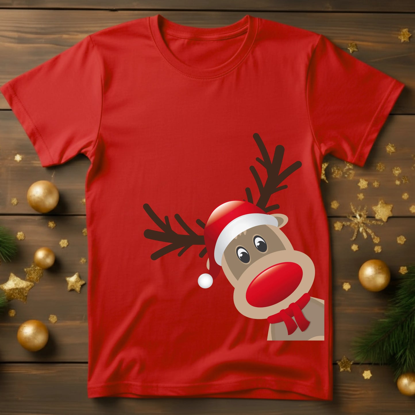 Red t-shirt with a reindeer design on a wooden surface with Christmas decorations.