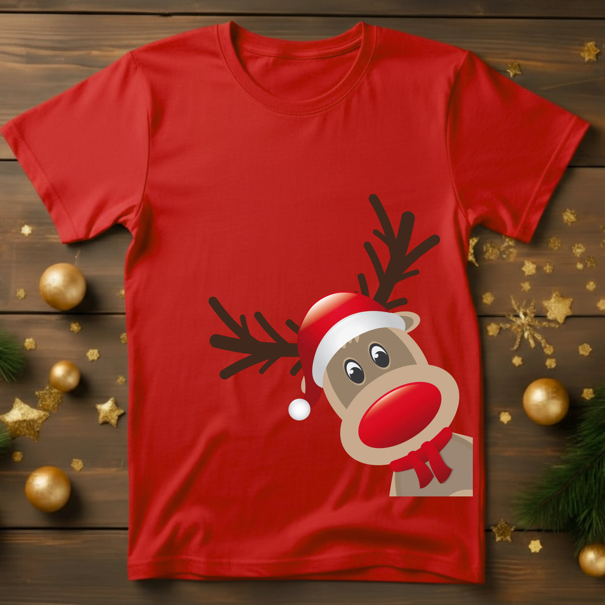 Red t-shirt with a reindeer design on a wooden surface with Christmas decorations.