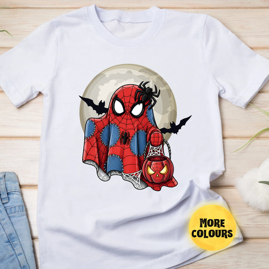 White t-shirt with Spider-Man design holding a pumpkin lantern on a wooden surface.
