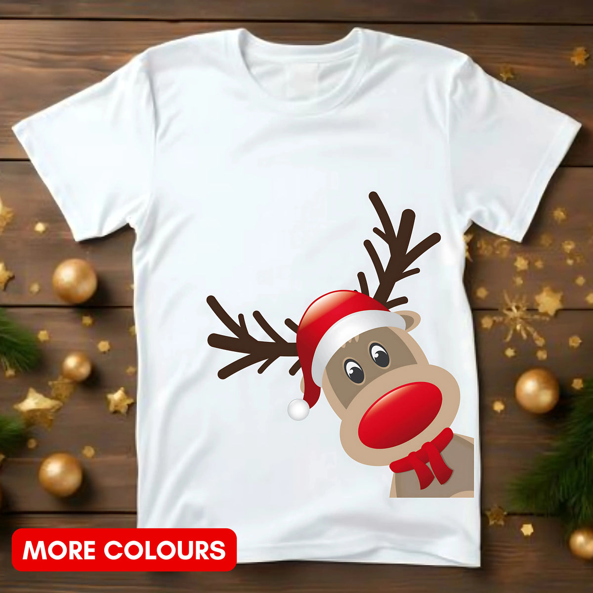 White t-shirt with a reindeer design wearing a Santa hat on a wooden surface with Christmas decorations.