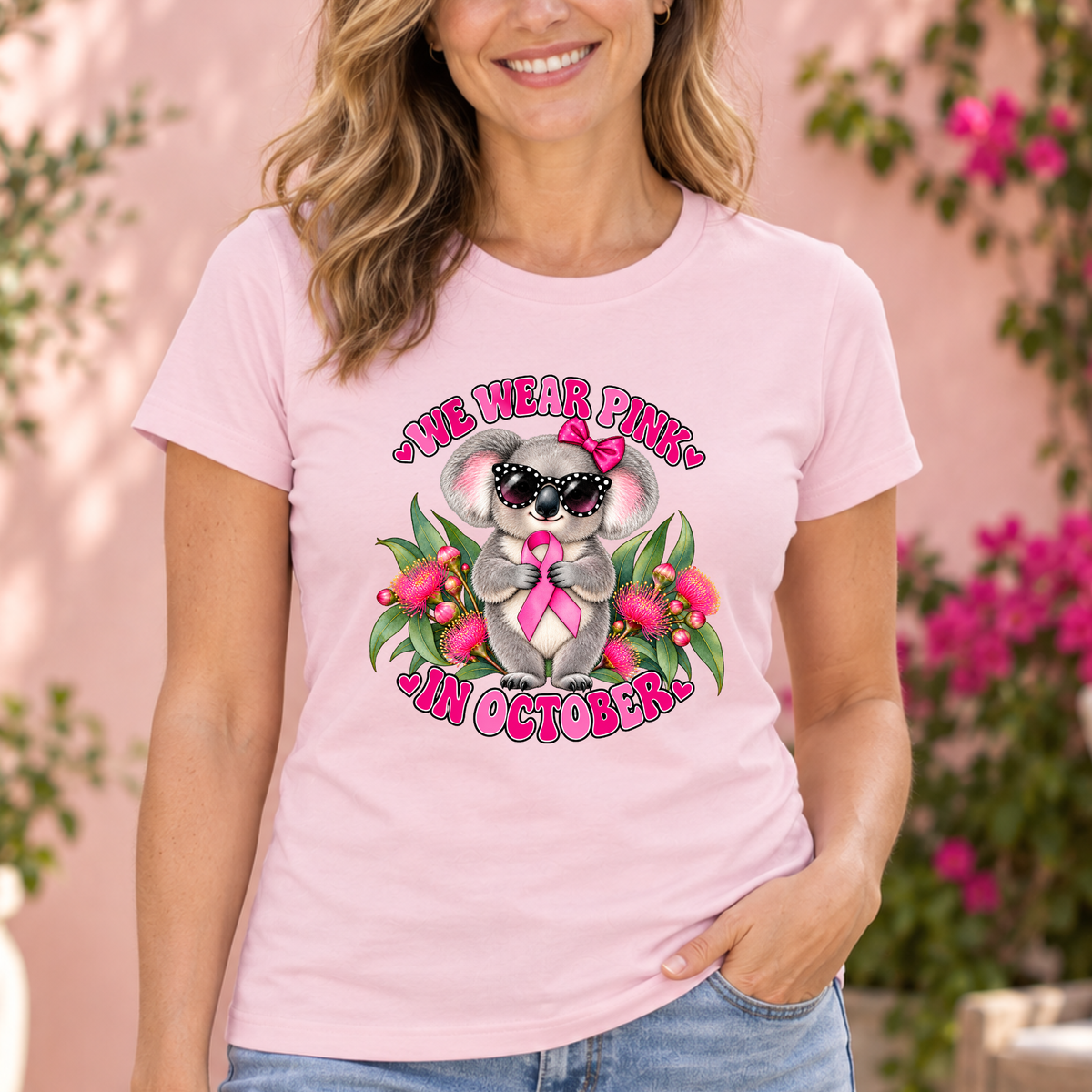 Woman wearing a powder pink We Wear Pink in October koala breast cancer awareness shirt